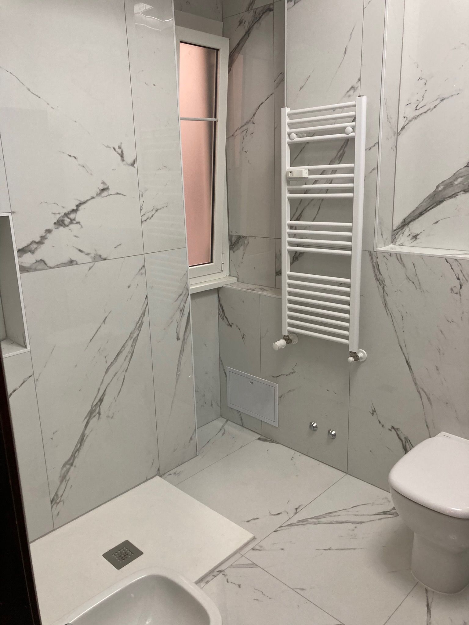 Un bagno con wc, lavandino e portasciugamani.