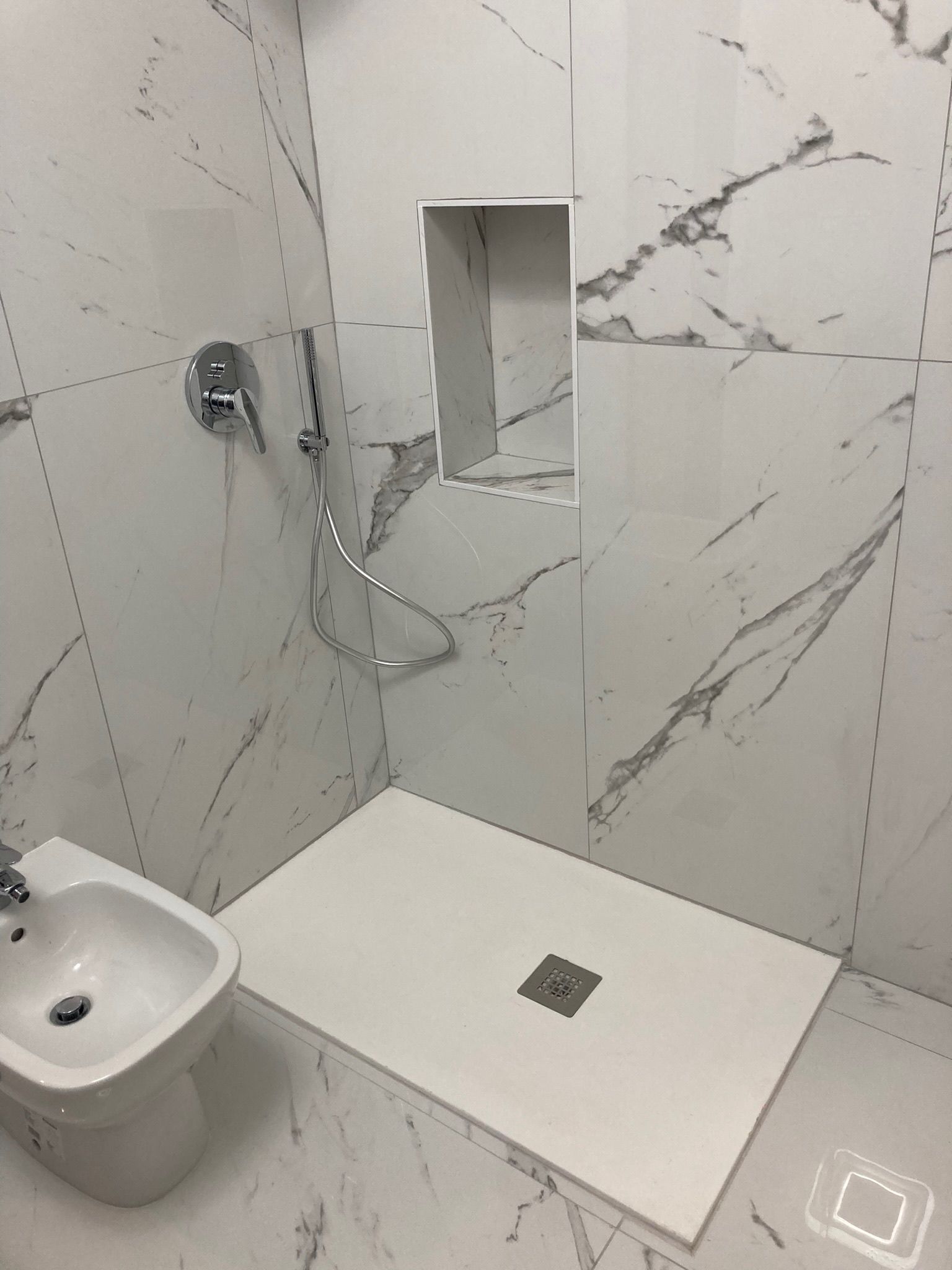 Un bagno con bidet, lavandino e doccia.