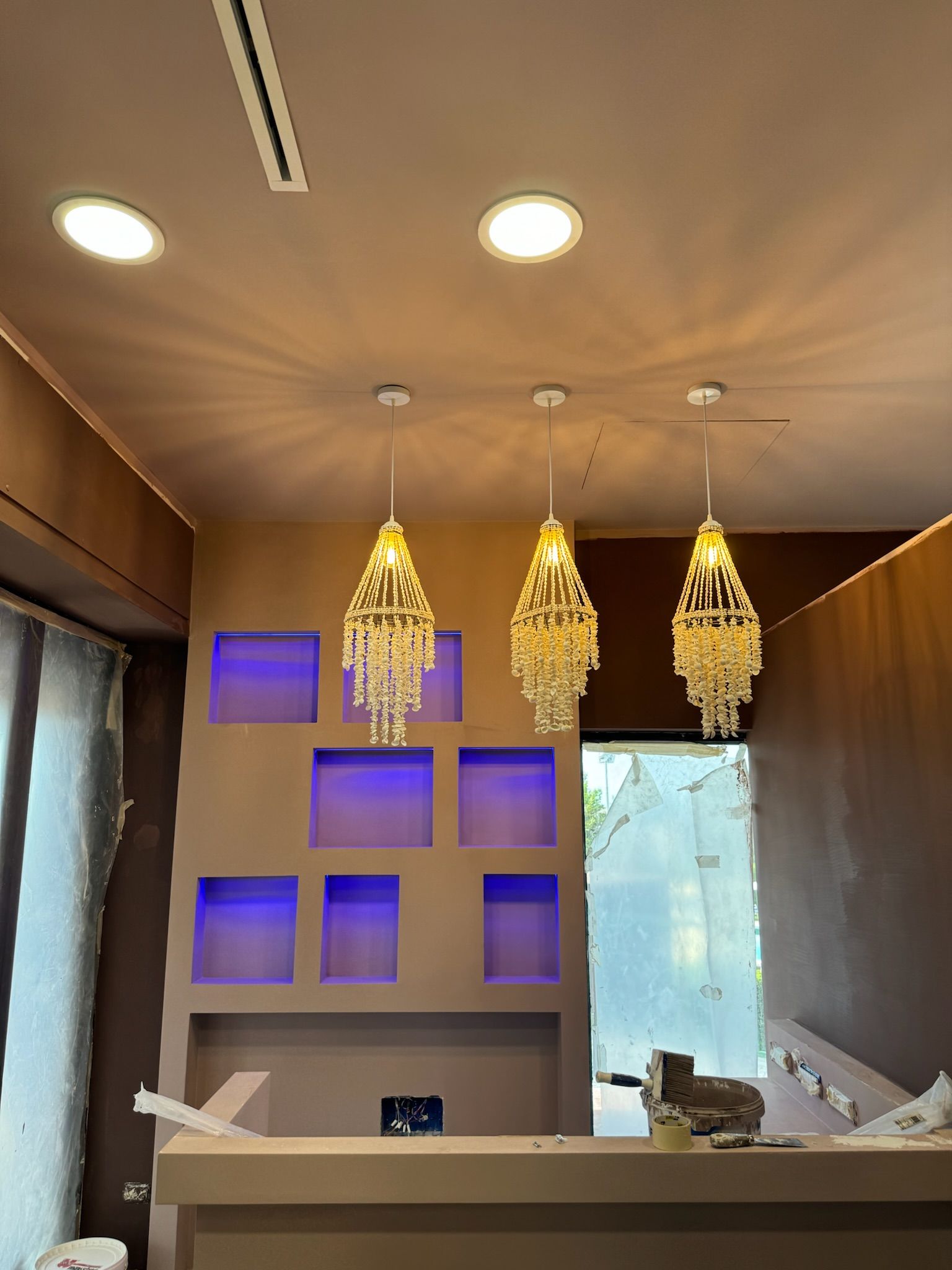 Una stanza con scaffali viola e due lampadari appesi al soffitto.