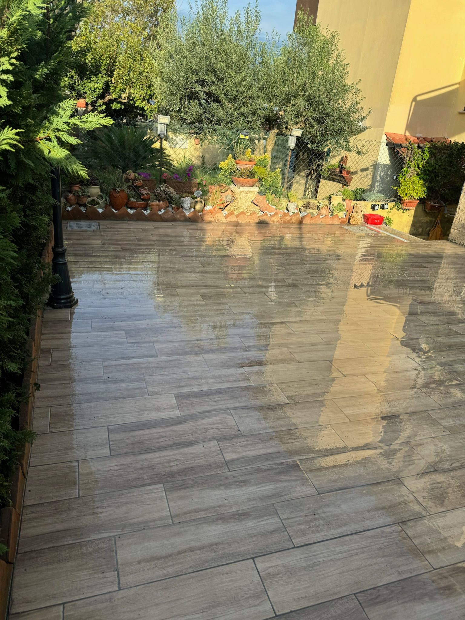 Un patio con tante piastrelle e alberi sullo sfondo.