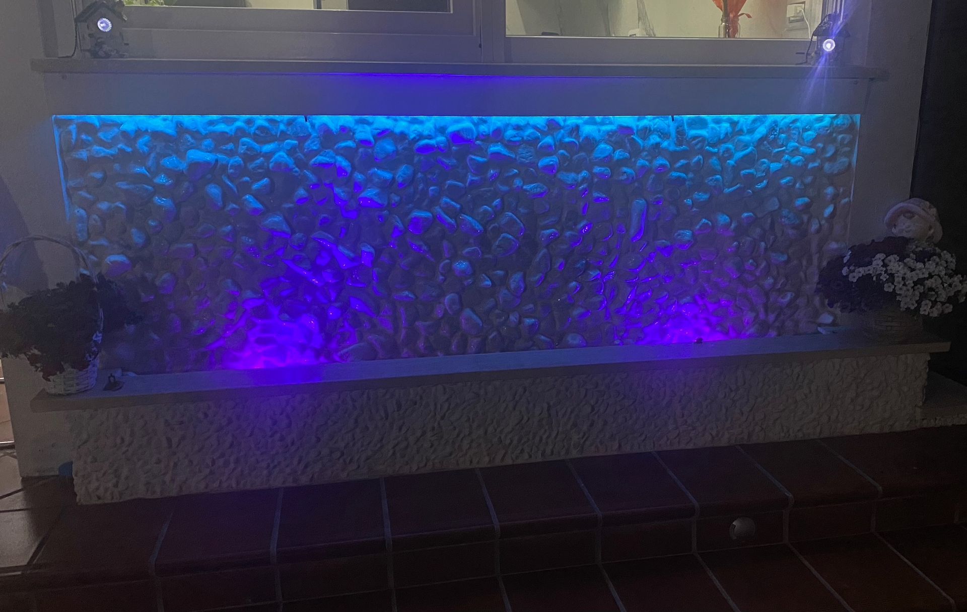 In una stanza c'è una fontana d'acqua con luci viola.