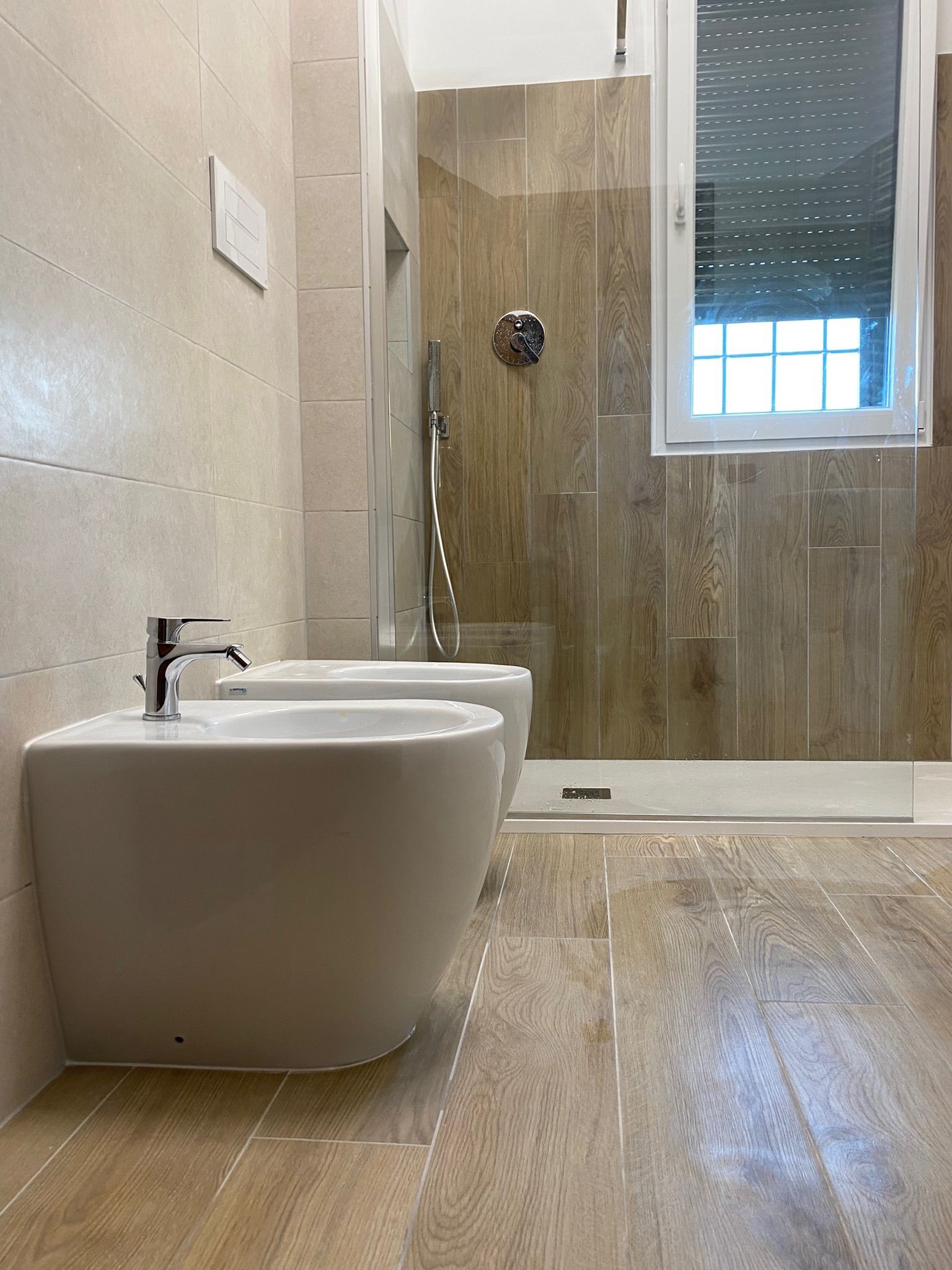 Un bagno con due wc e cabina doccia.