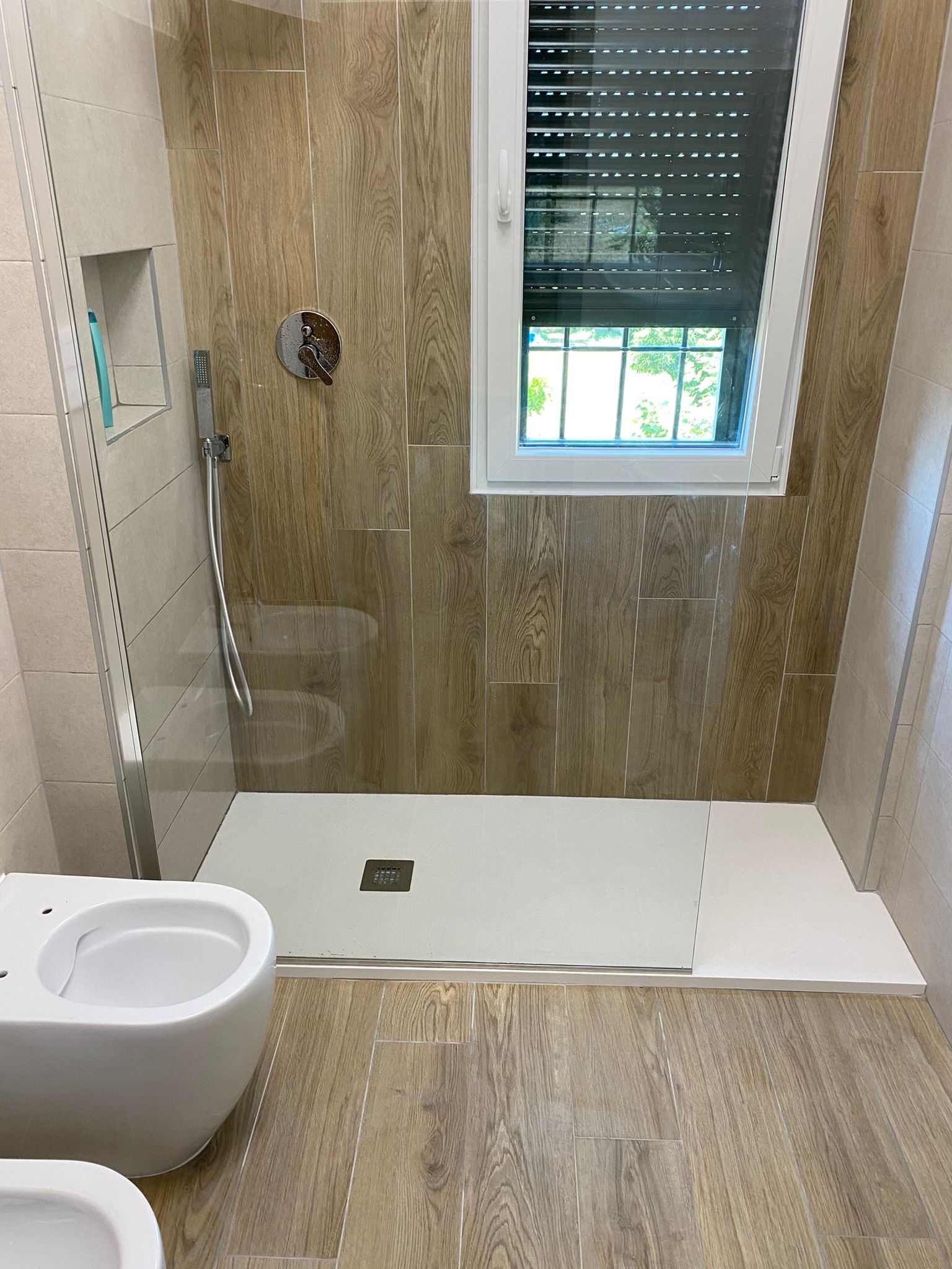 Un bagno con wc, doccia e finestra.