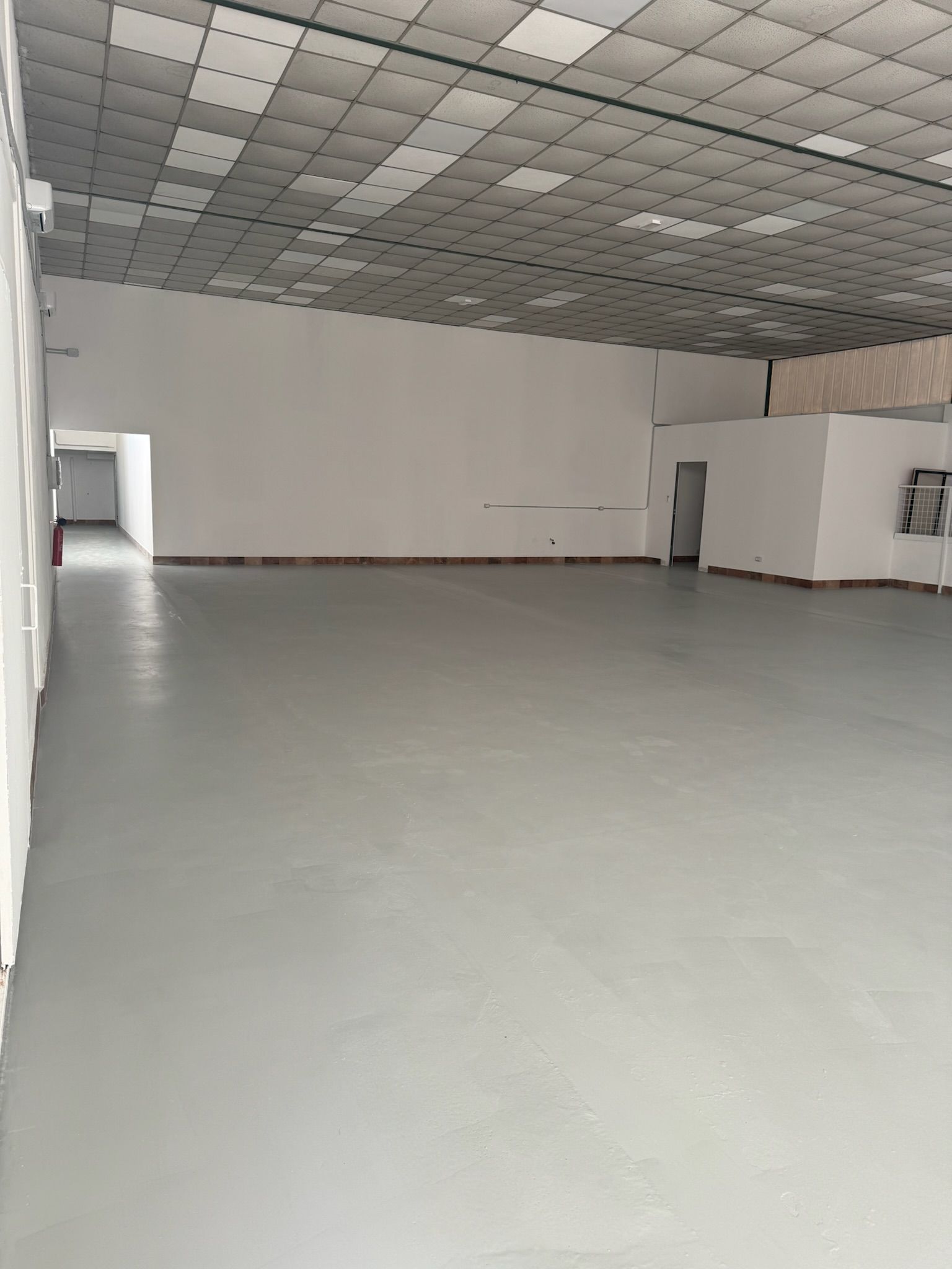 Una grande stanza vuota con pavimento e soffitto bianchi.