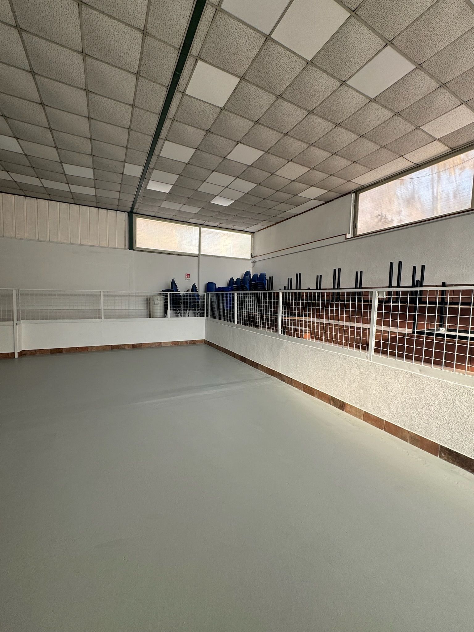 Una grande stanza vuota con tavoli e sedie