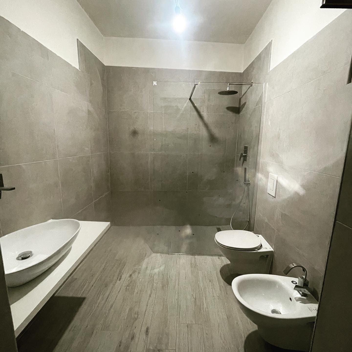 Un bagno con due lavandini, un water e una cabina doccia.