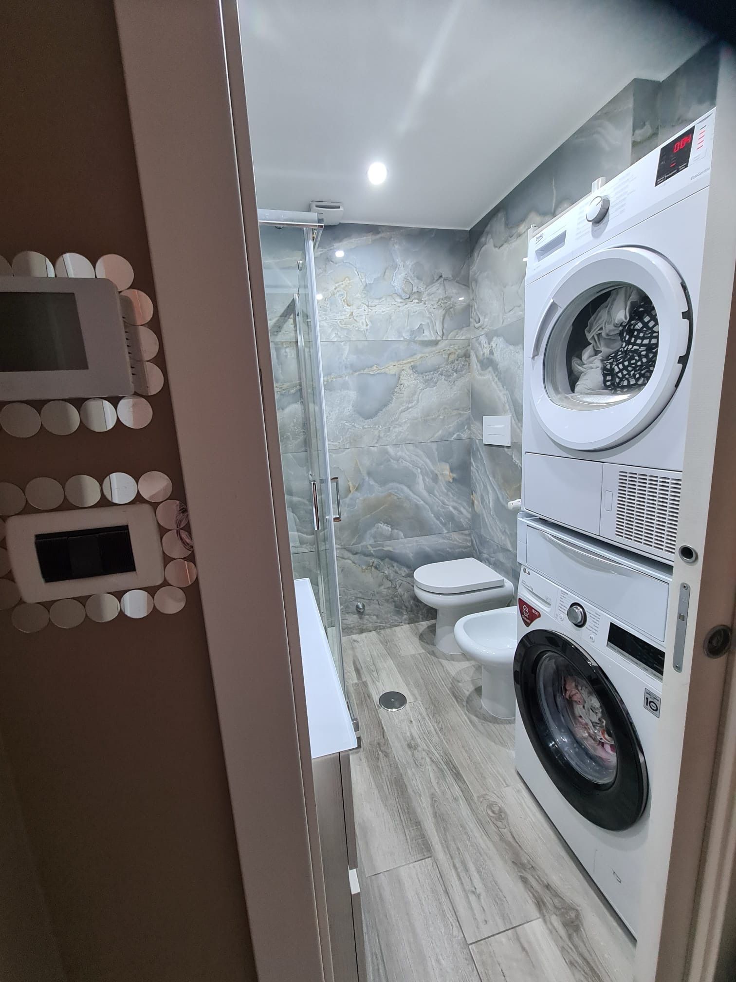 Un bagno con lavatrice e asciugatrice impilate l'una sull'altra.