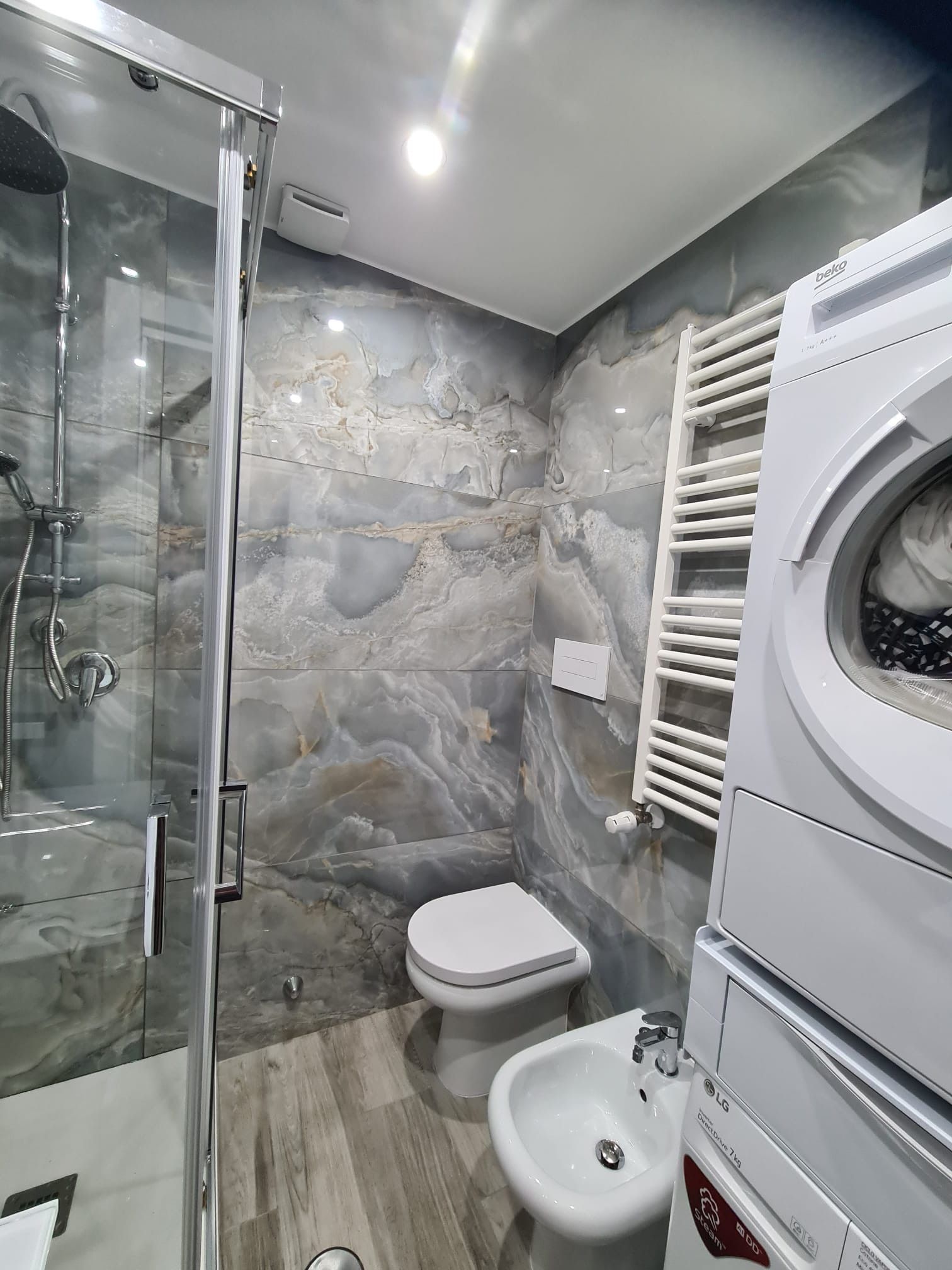 Un bagno con wc, bidet, lavatrice e asciugatrice.