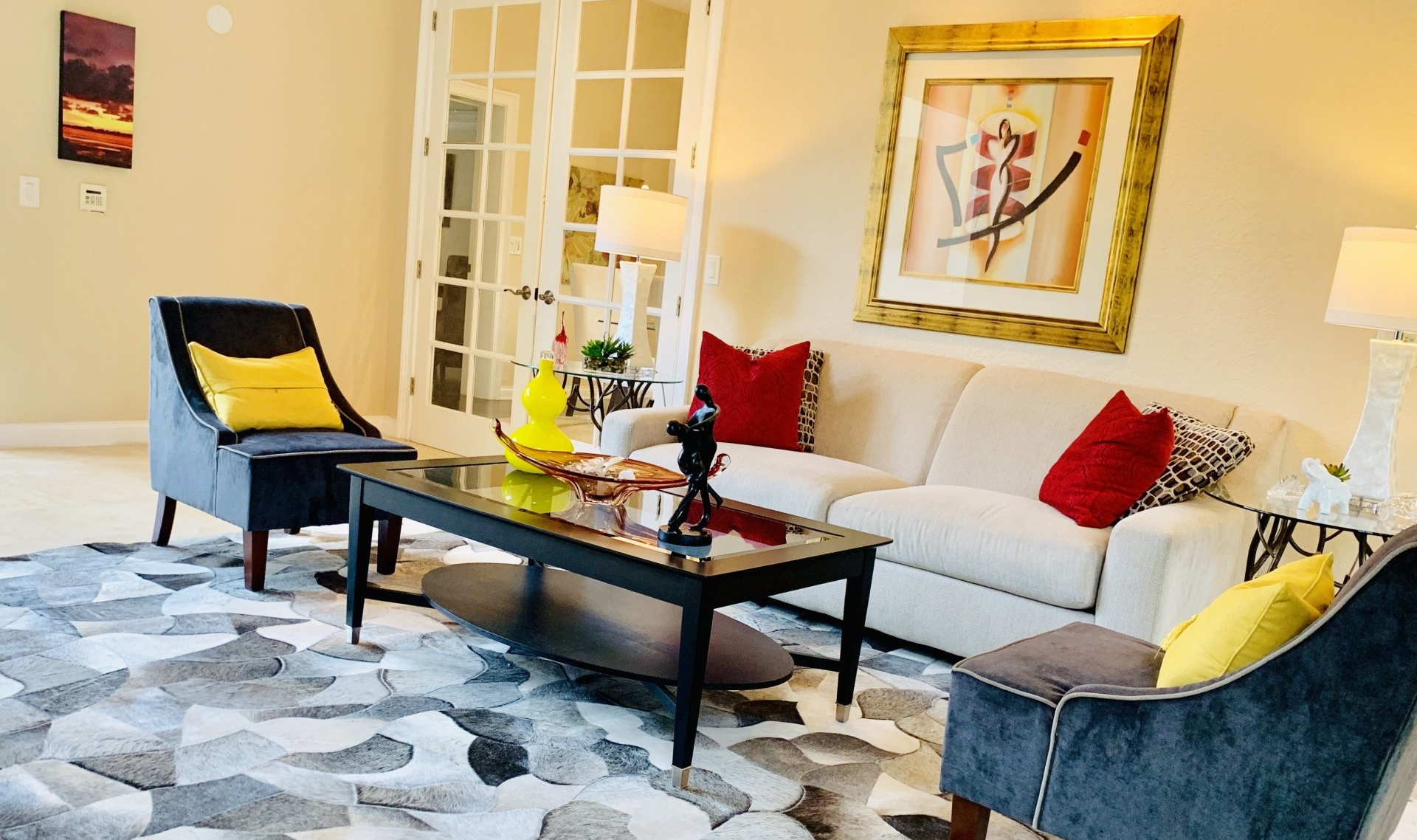 A living room with a couch , chairs , a coffee table and a rug.