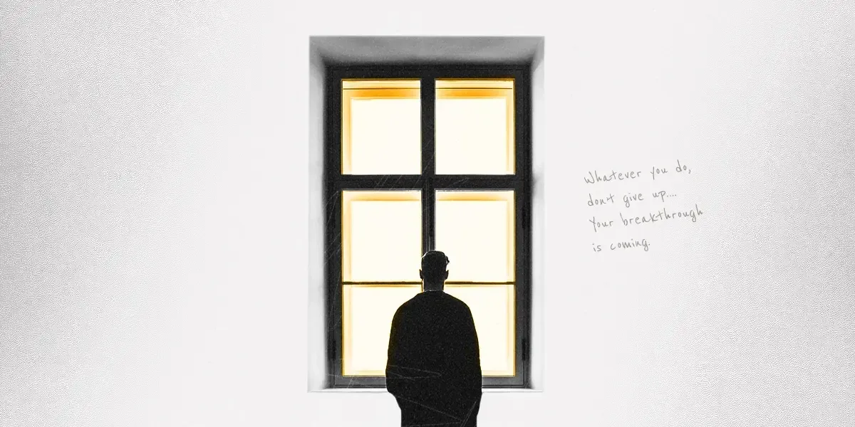 Silhouette of a person looking out of a brightly lit window. Handwritten text is beside the window.