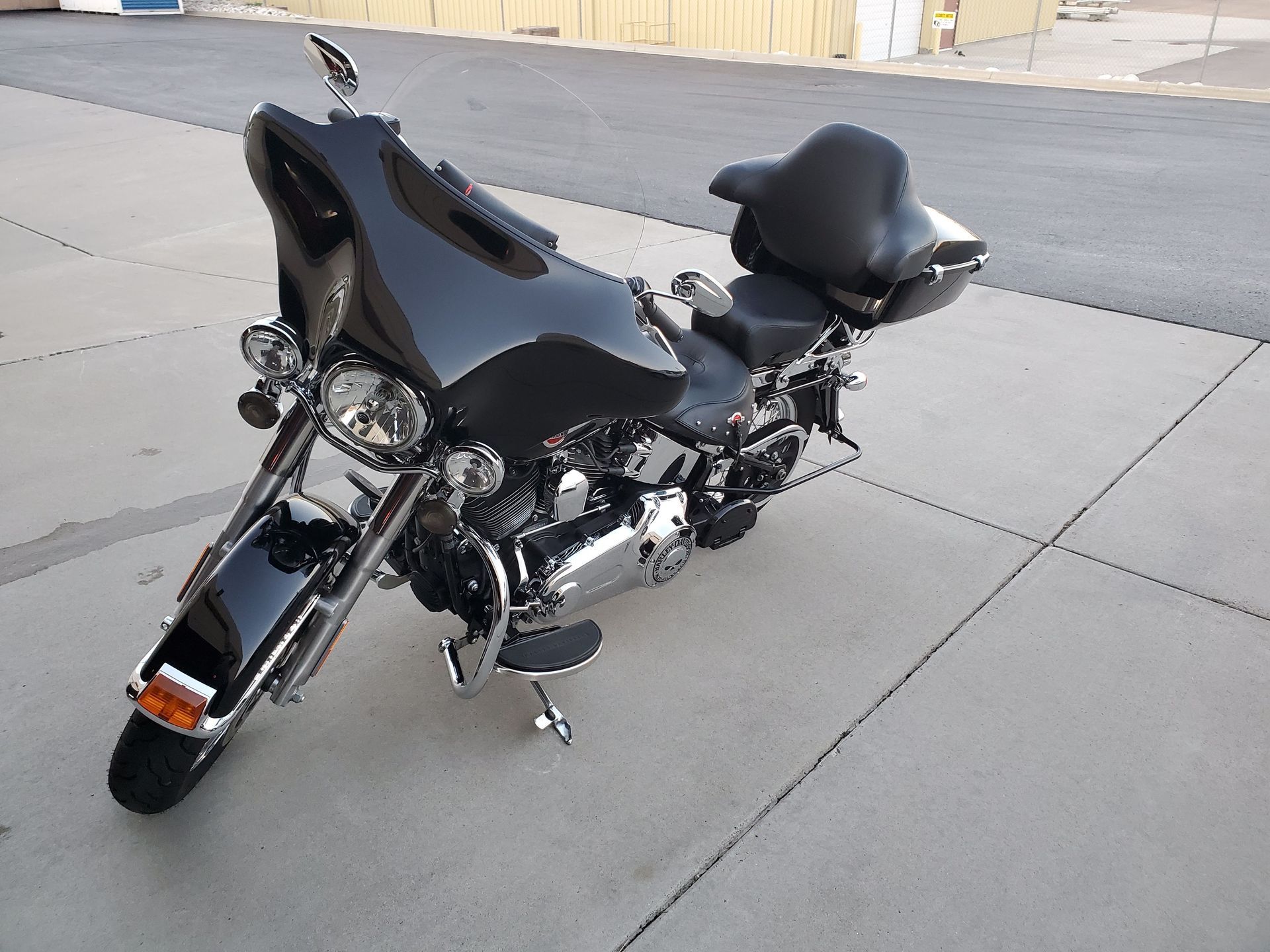 A black harley davidson motorcycle is parked on the sidewalk