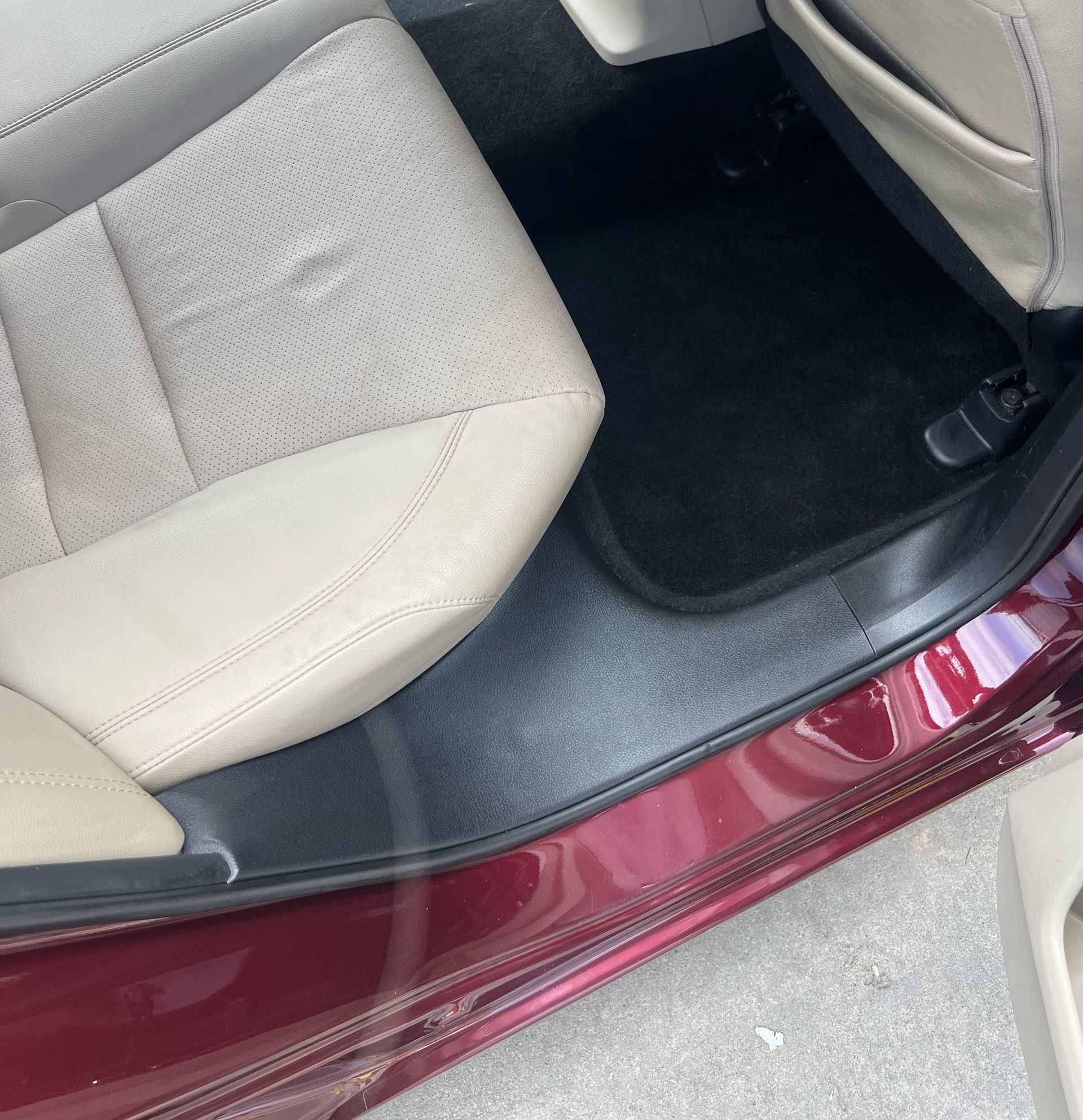 The inside of a red car with tan seats