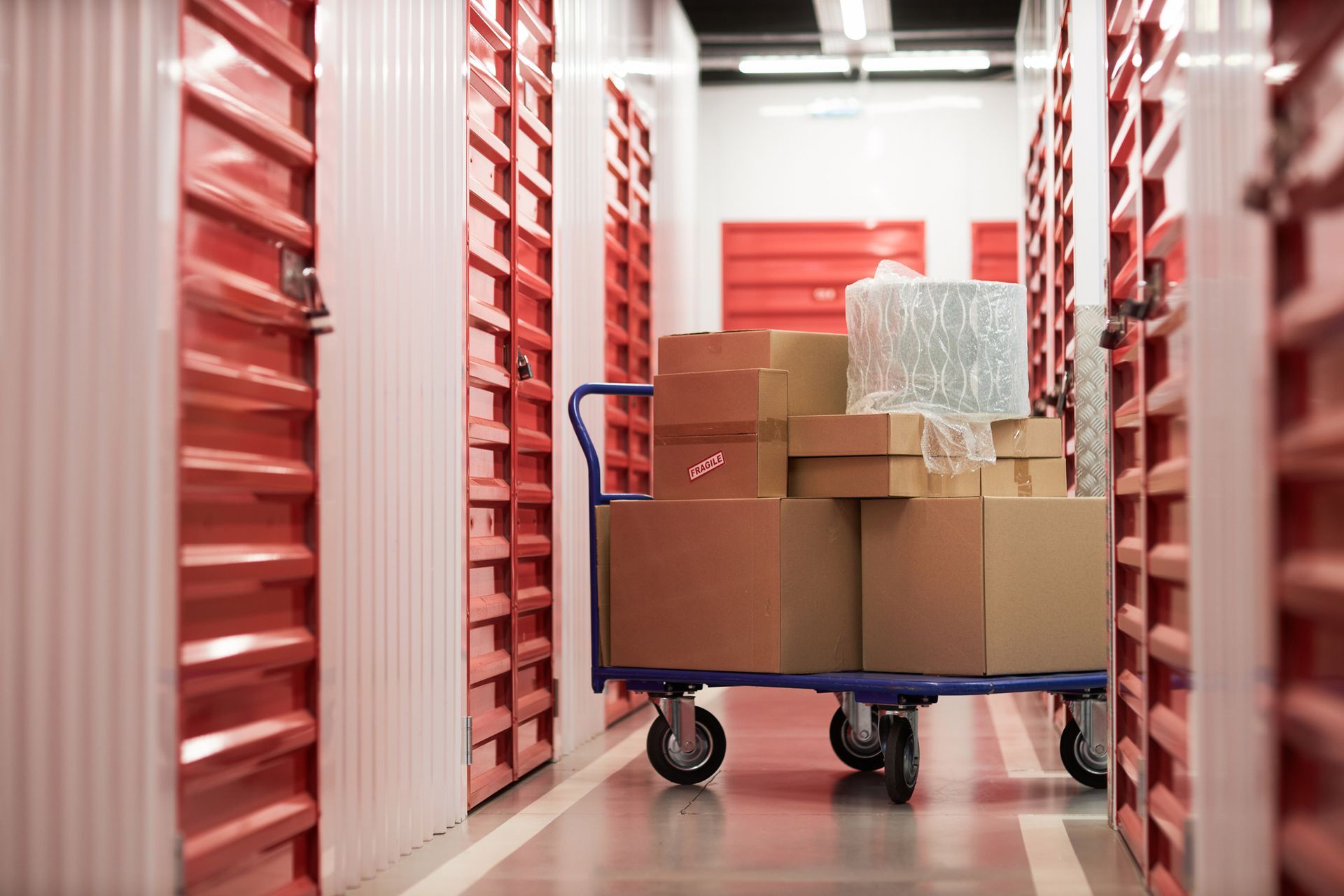 A cart with cardboard boxes in a corridor of self-storage