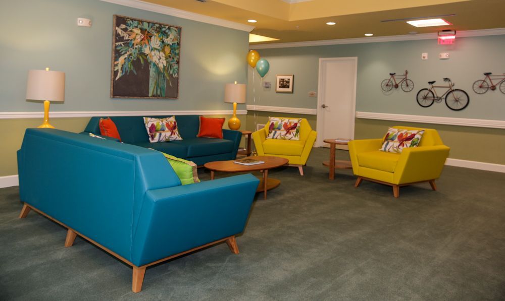 A living room with a blue couch and yellow chairs