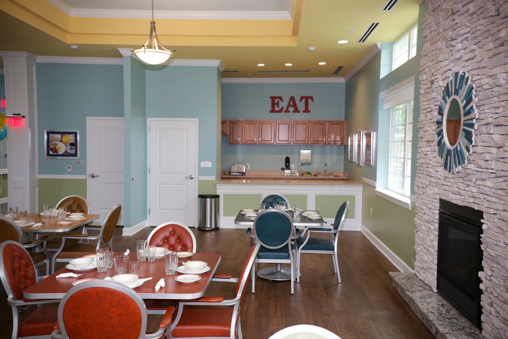 A restaurant with tables and chairs and a sign that says eat