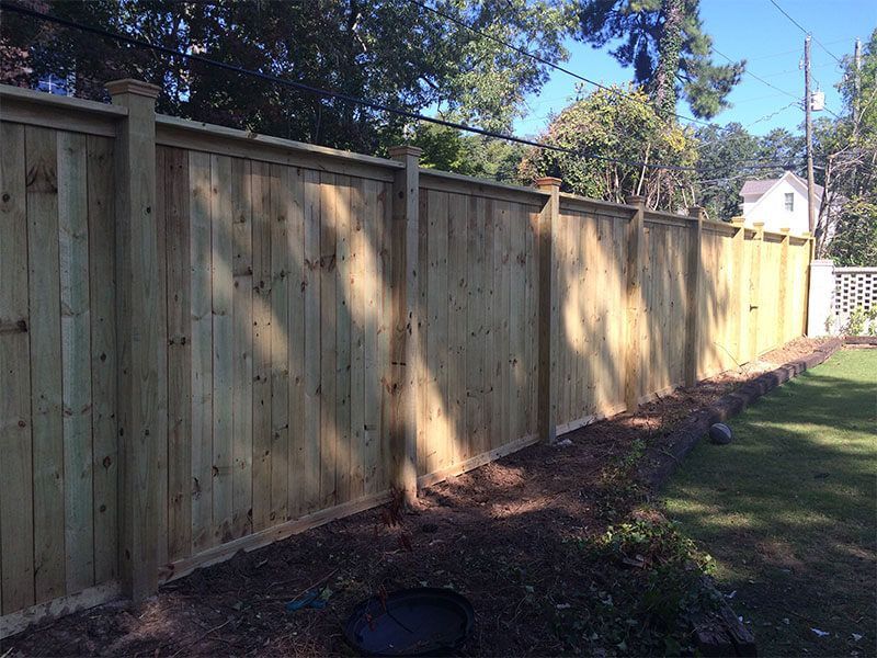 A wooden fence is sitting in the middle of a yard.
