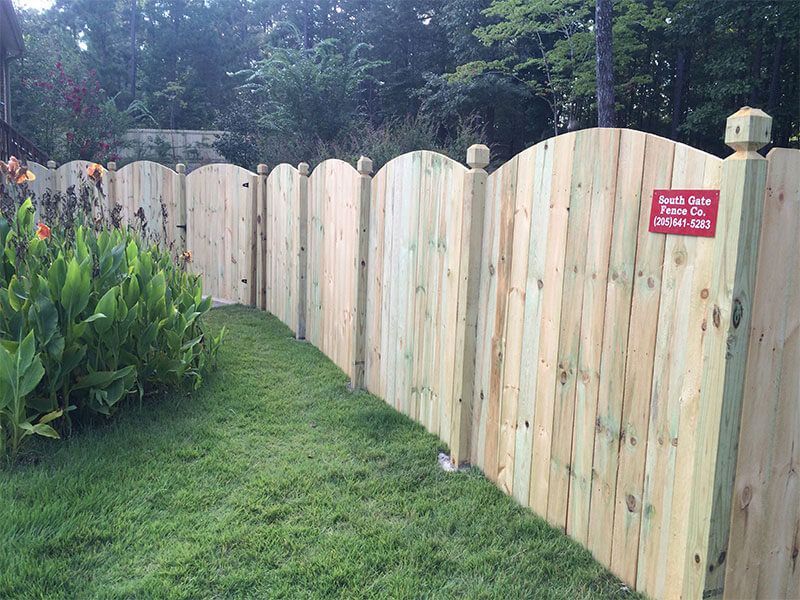 A wooden fence is sitting on top of a lush green lawn.