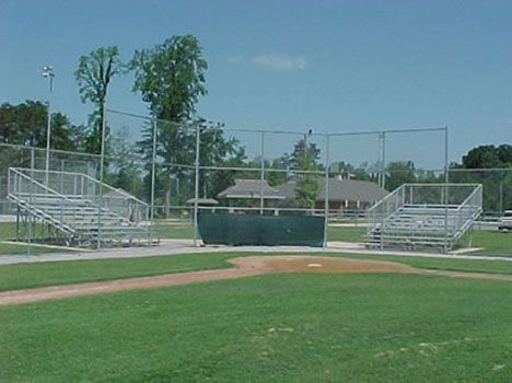 A baseball field with bleachers and a fence