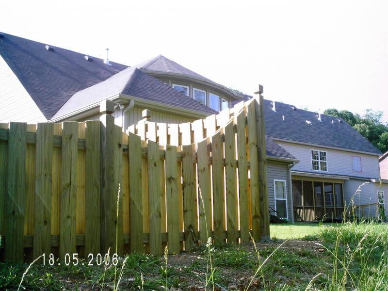 A wooden fence in front of a house that was taken in 2006