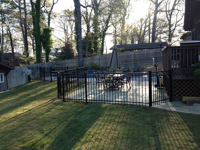 A backyard with a fence and a swimming pool