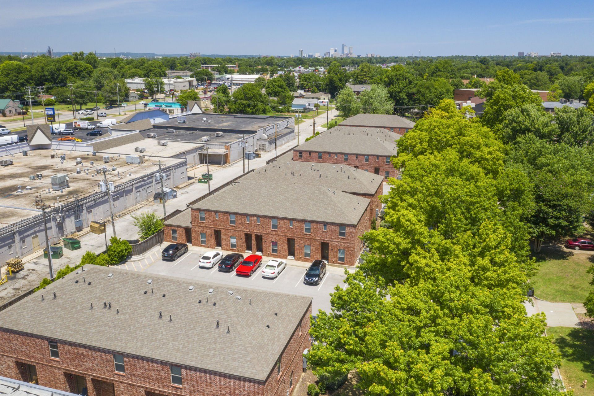 An aerial view of a brick apartment building with cars parked in front of it.