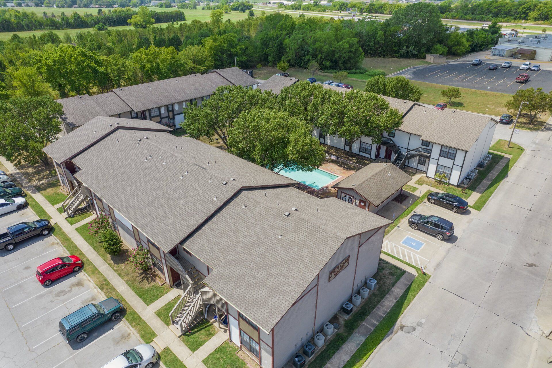 An aerial view of a large apartment complex with a swimming pool.