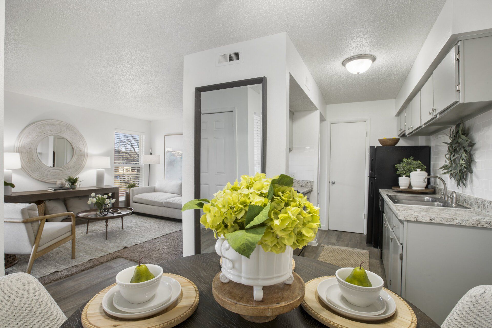 A dining room table with plates and bowls on it and a vase of flowers on it.