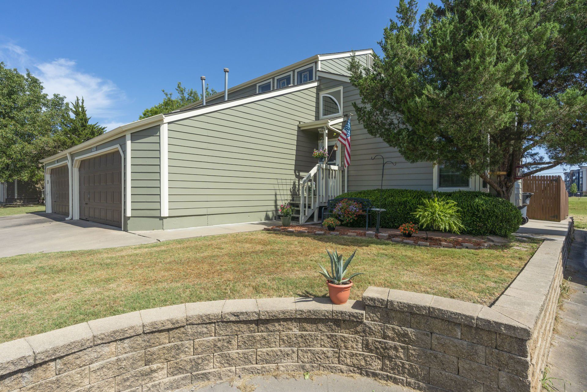 A house with a brick wall in front of it.