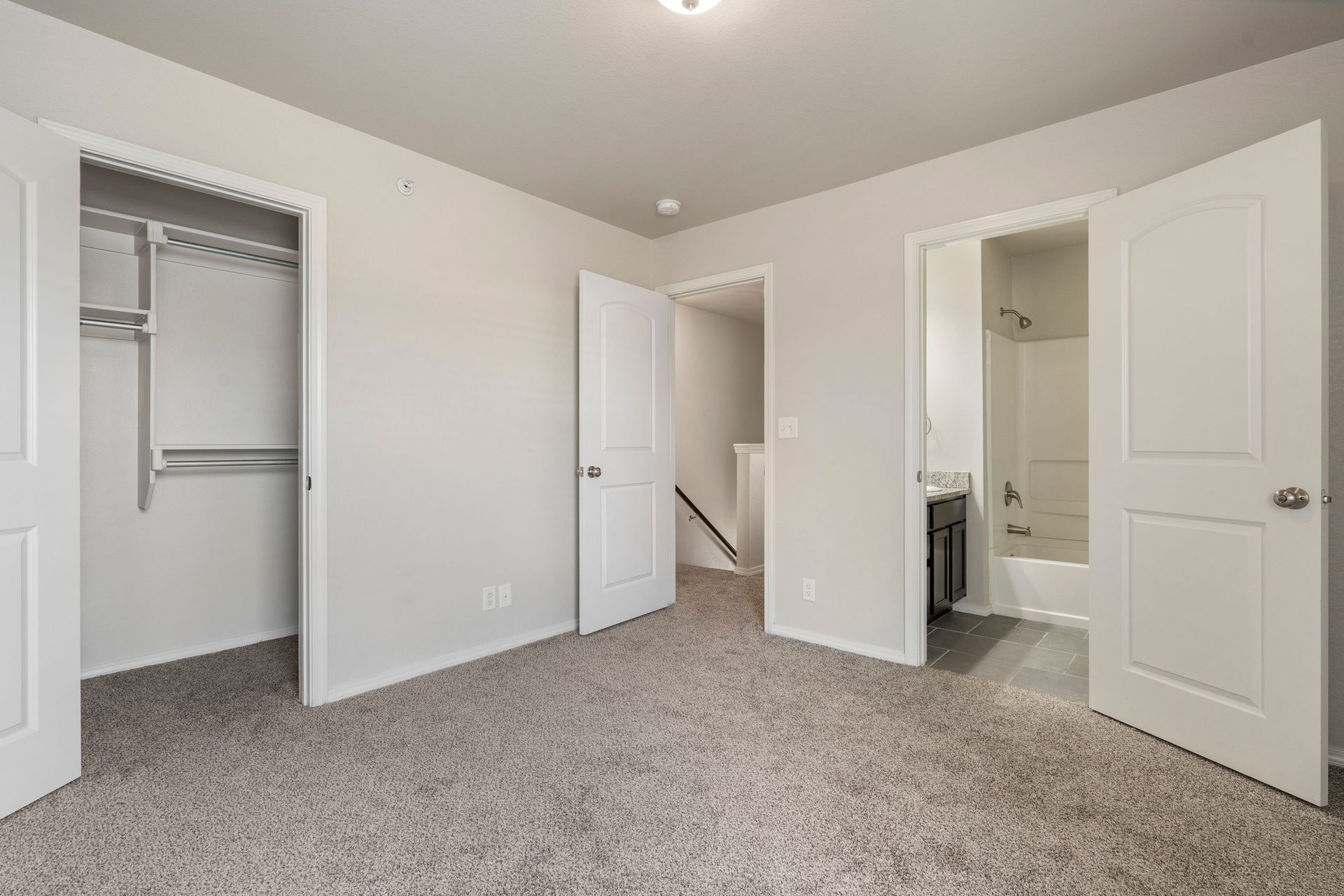 An empty bedroom with a walk in closet and a bathroom.