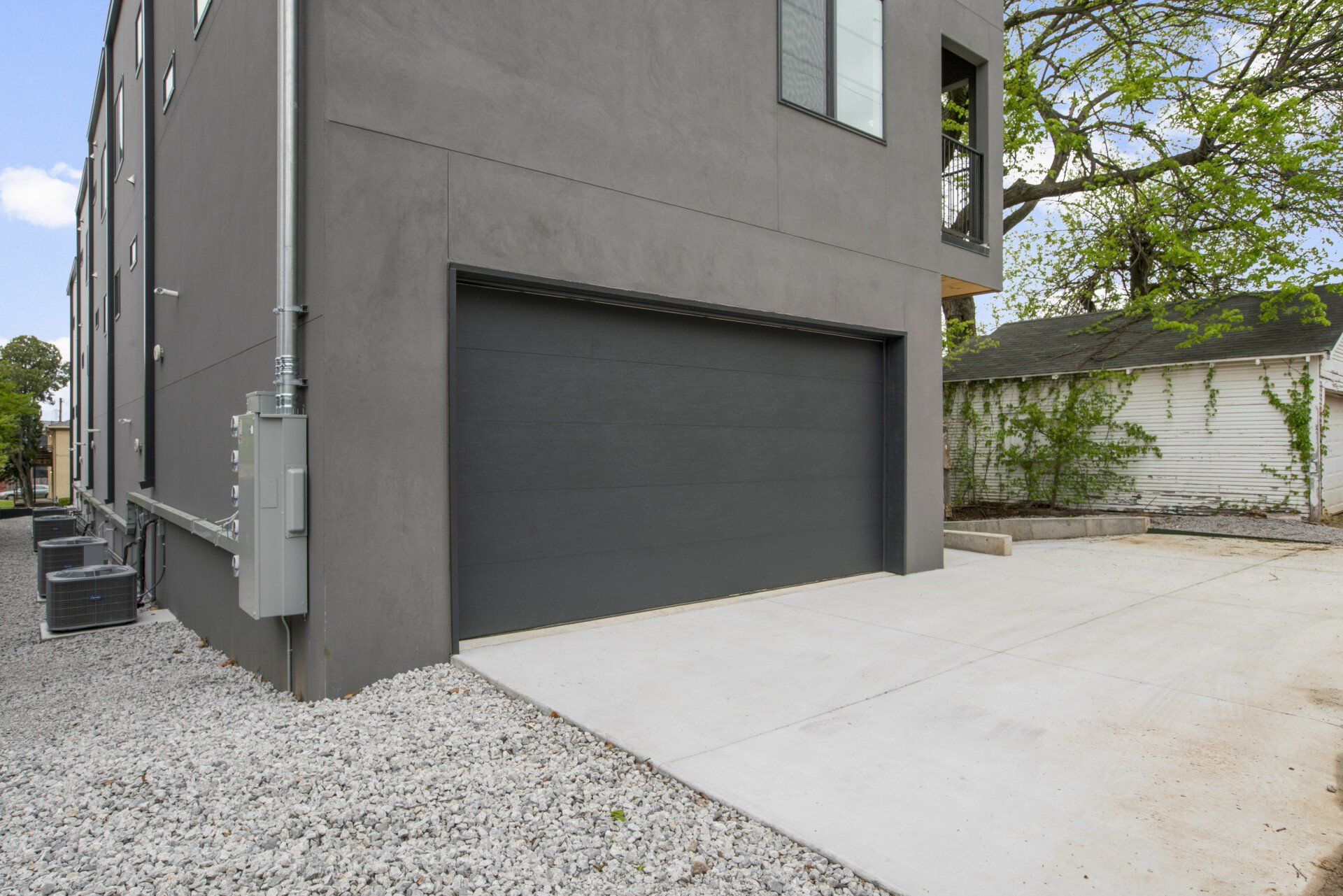 A black garage door is on the side of a building.