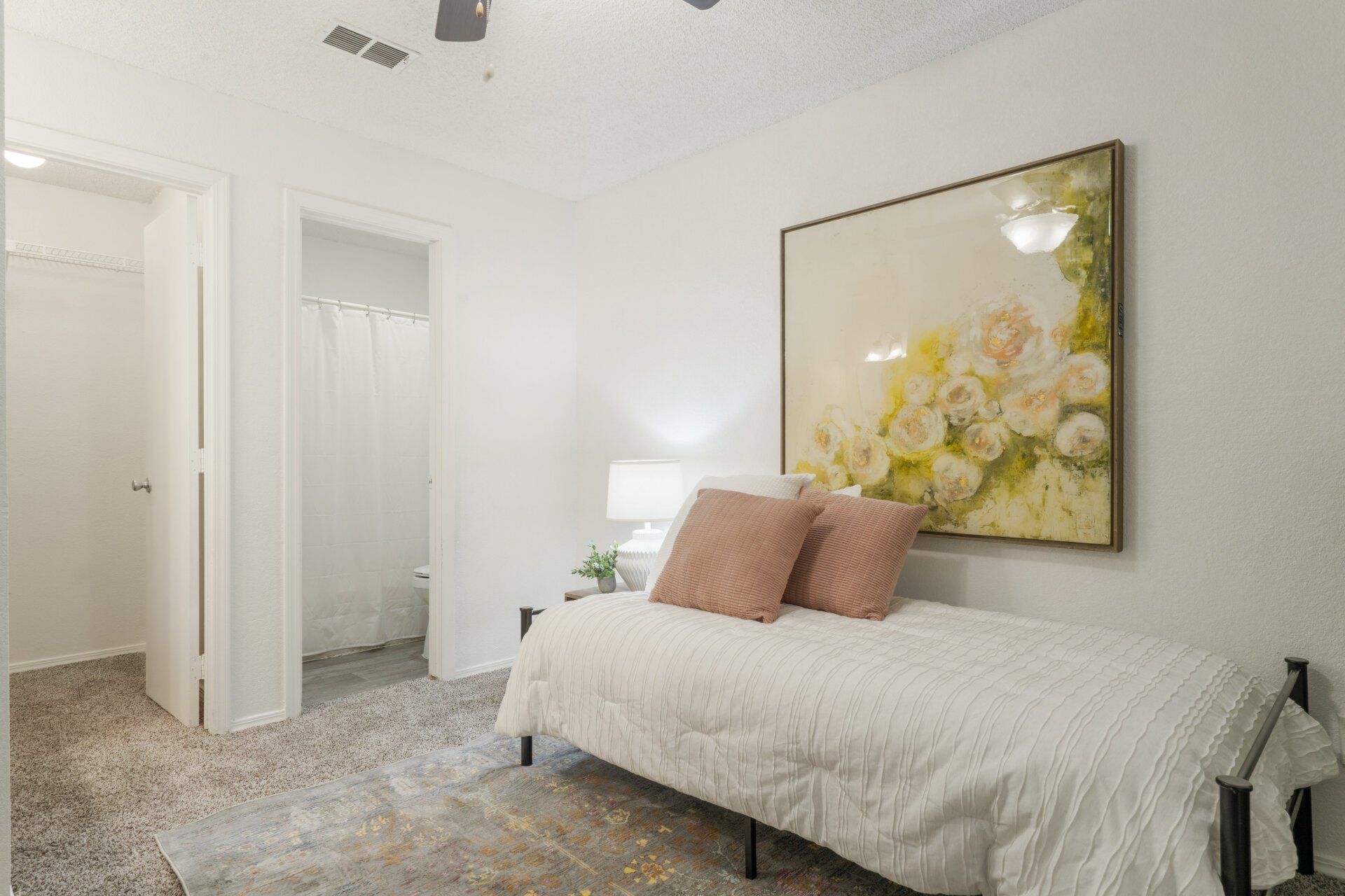 A bedroom with a bed and a painting on the wall.