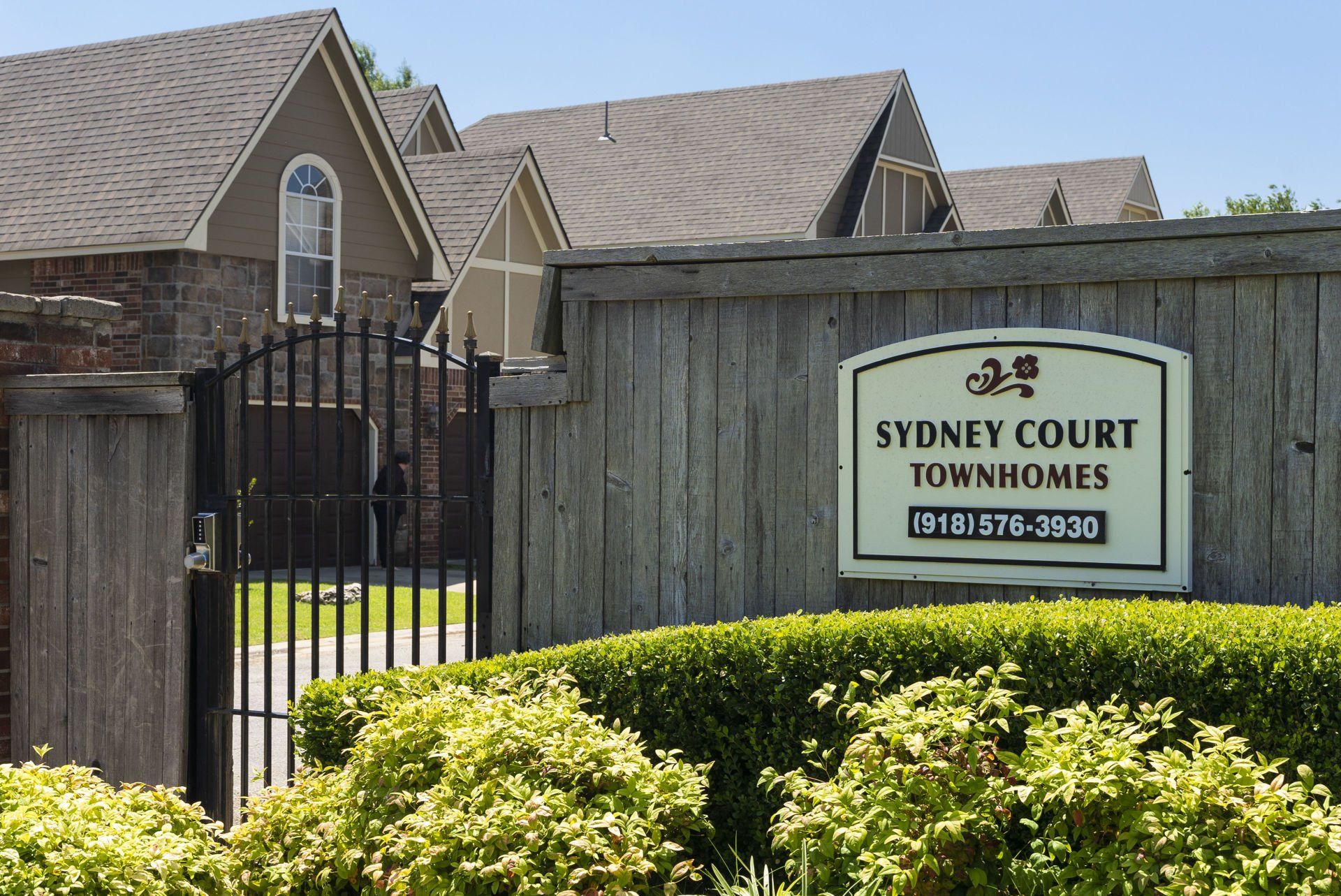A fence with a sign that says sydney court townhomes