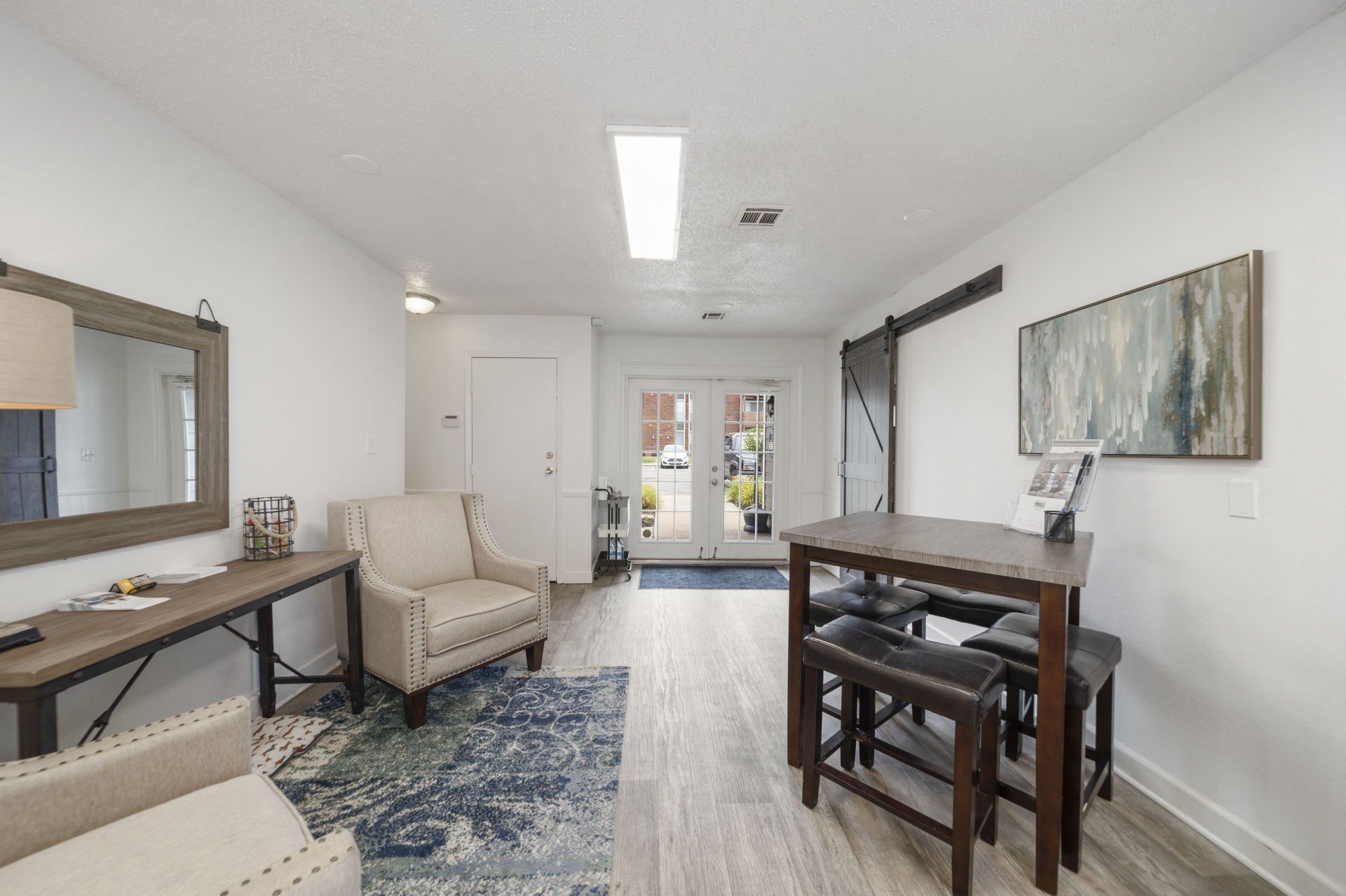 A living room with a table and chairs and a mirror.