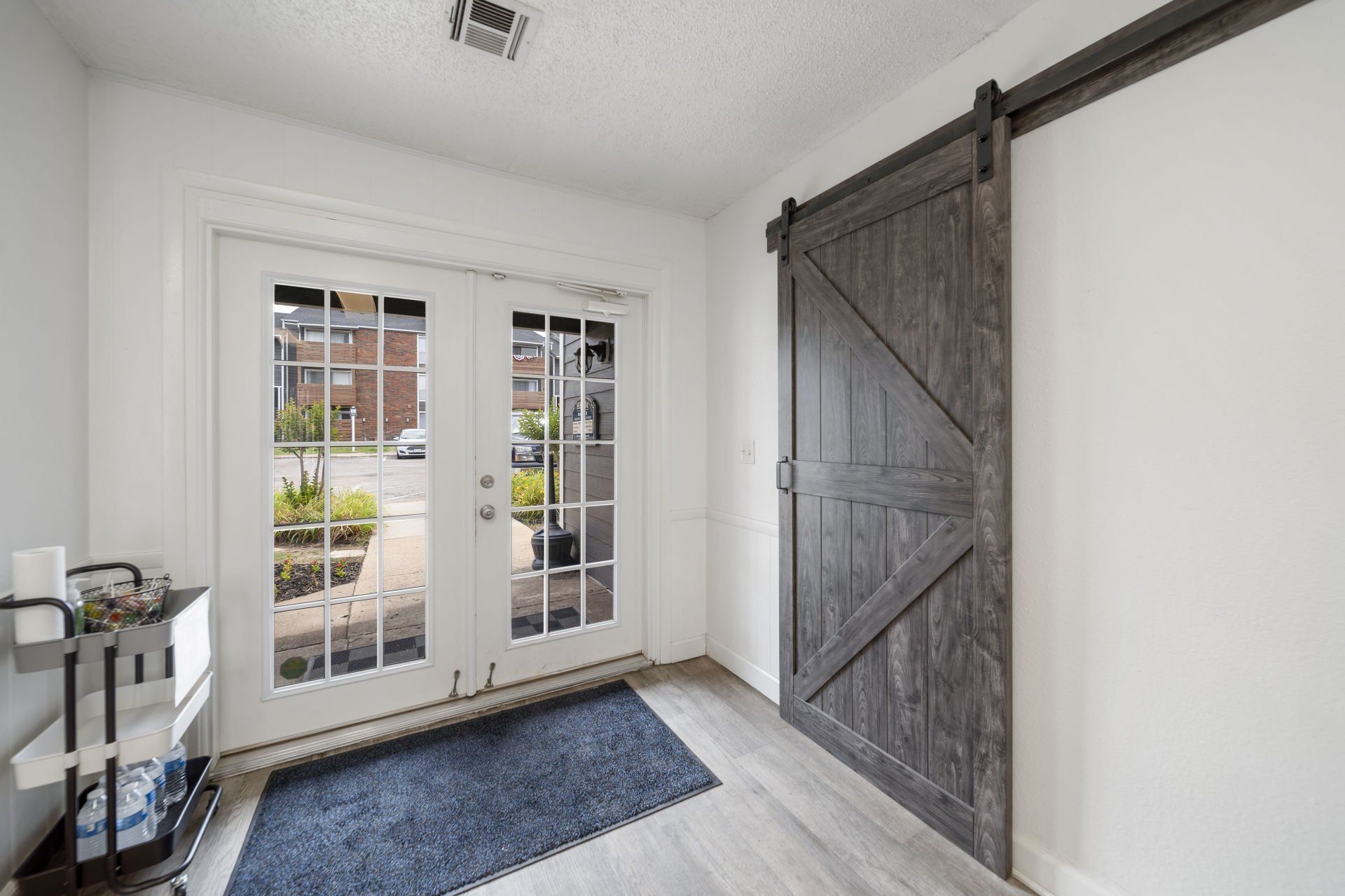 A room with a sliding barn door and french doors.