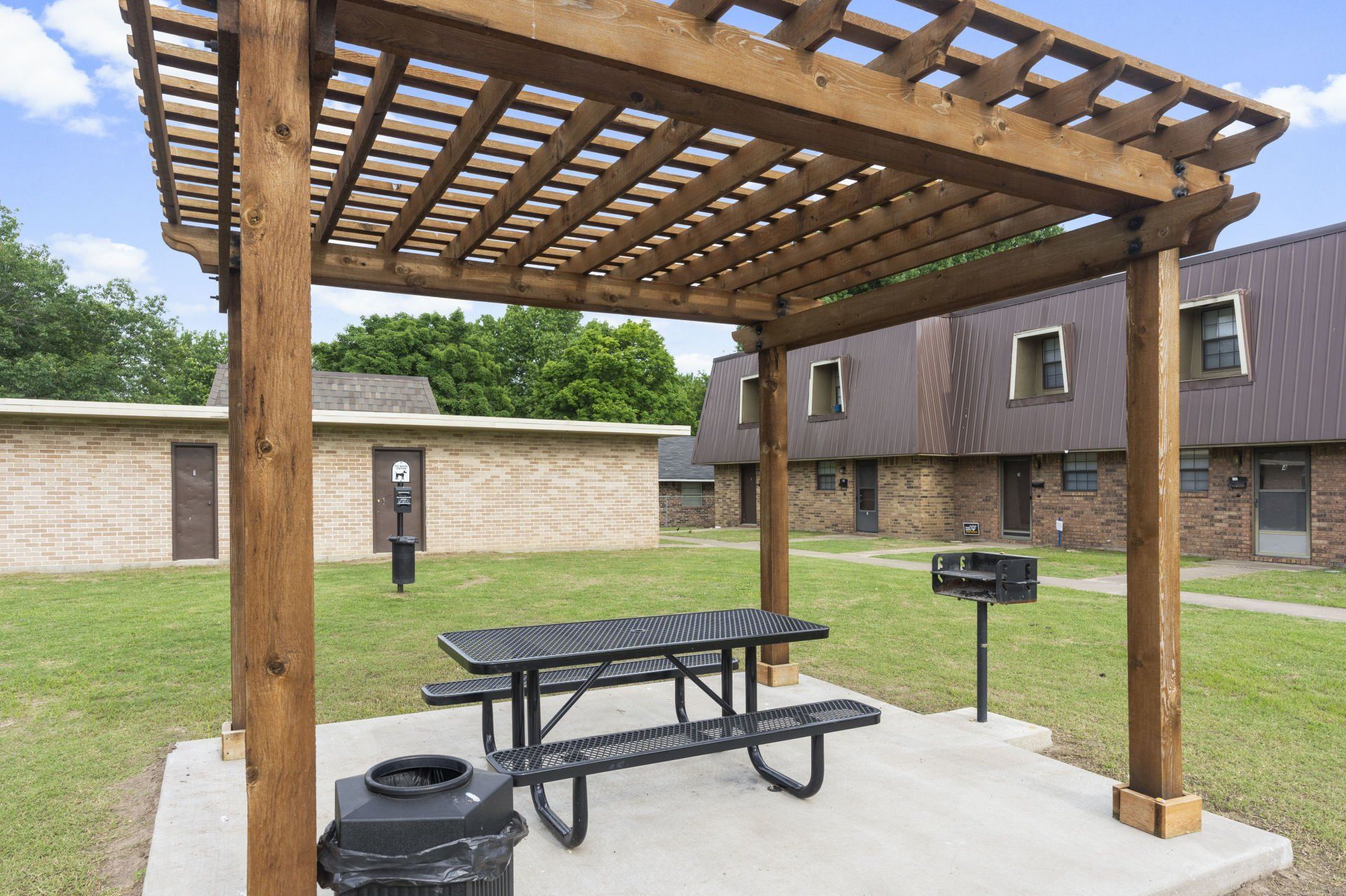 A wooden pergola with a picnic table underneath it.