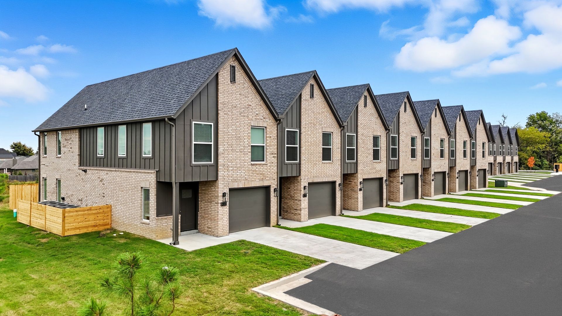An artist 's impression of a row of houses with cars parked in front of them.