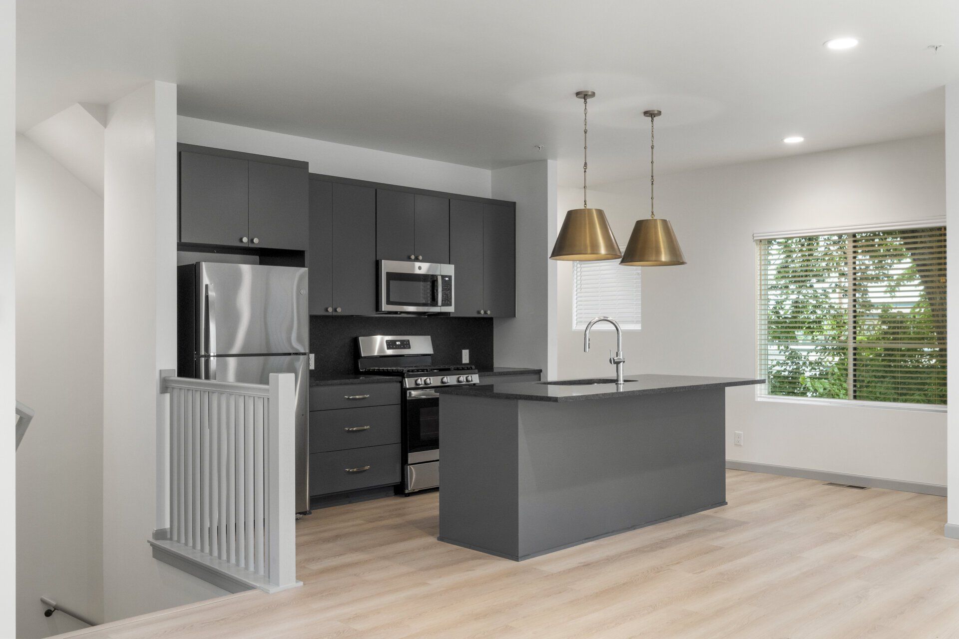 A kitchen with stainless steel appliances and gray cabinets