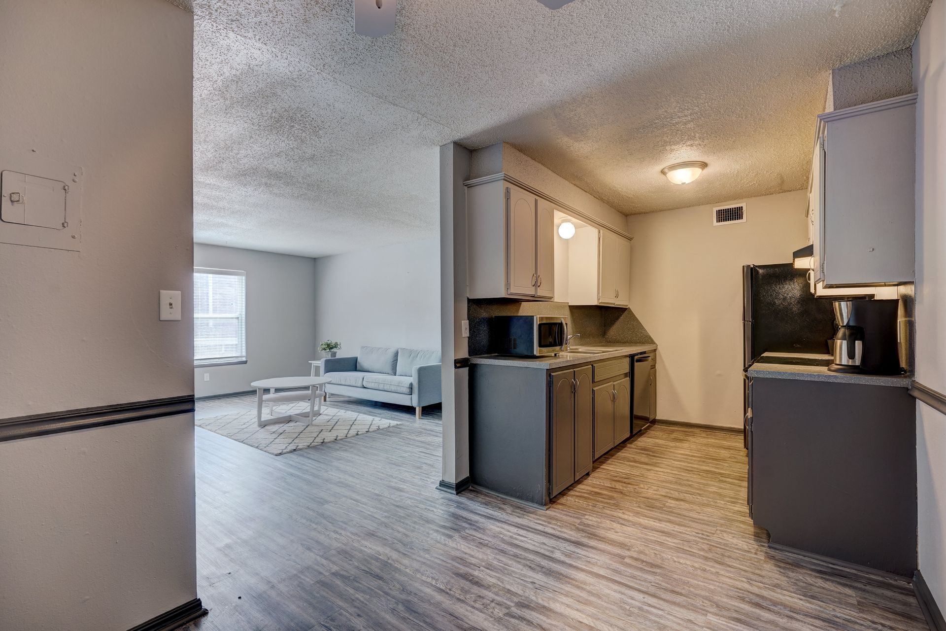 A kitchen and living room in a house with hardwood floors.