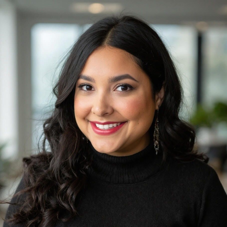 The woman is wearing a black jacket and smiling for the camera.