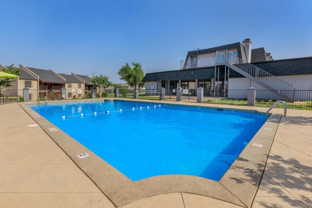 There is a large swimming pool in front of a building.