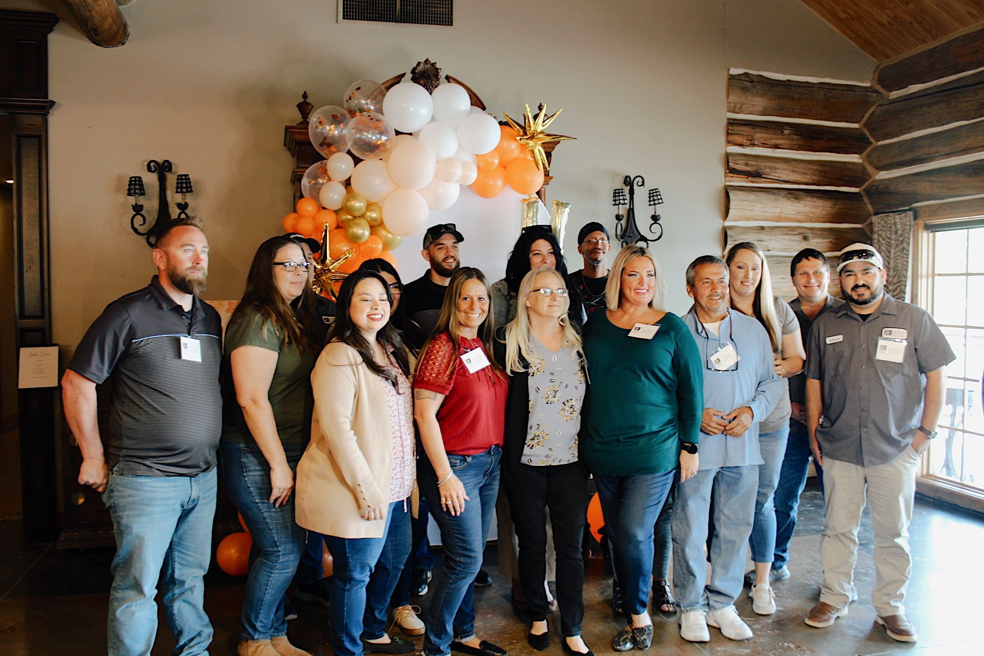A group of people are sitting at tables in a room with a projector screen.