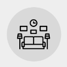 An icon of a living room with a couch , lamps , and a clock.