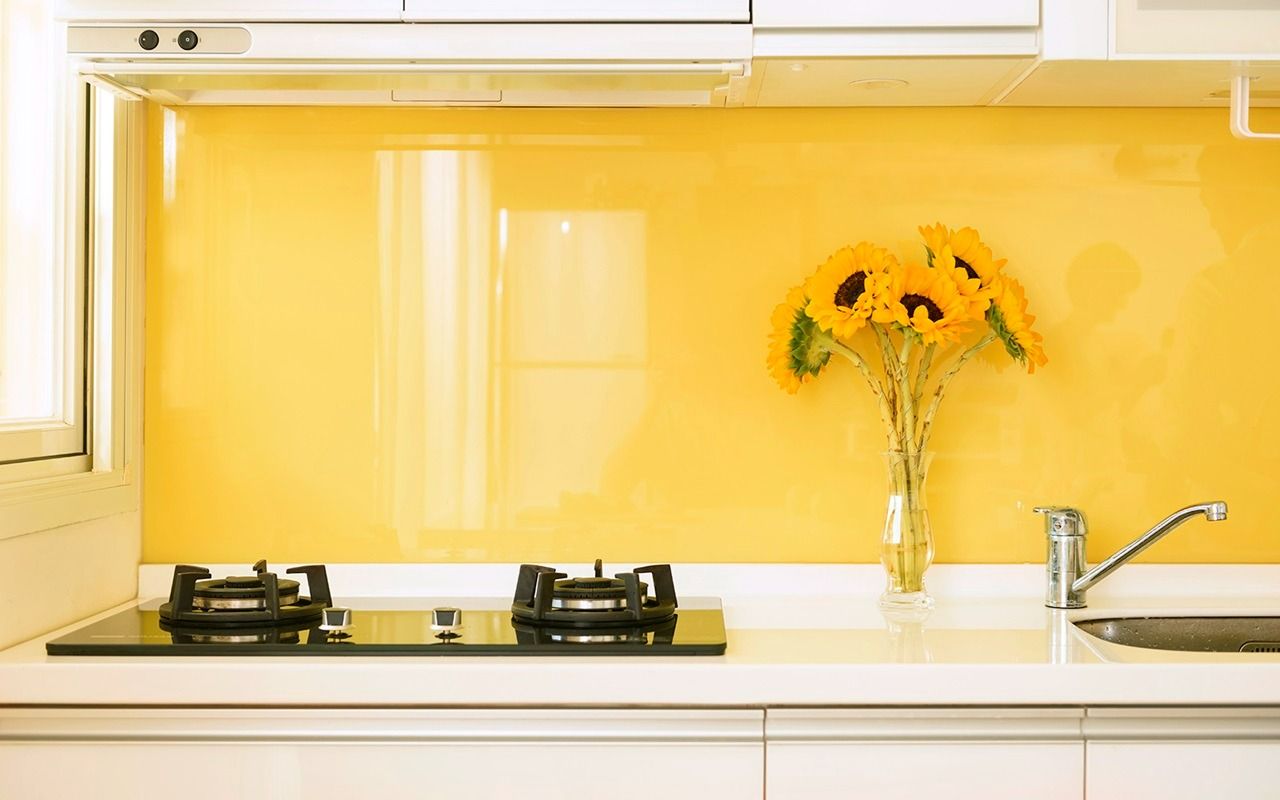 A Kitchen With A Yellow Wall And A Vase Of Sunflowers On The Counter — New England Glass & Aluminium In Armidale, NSW