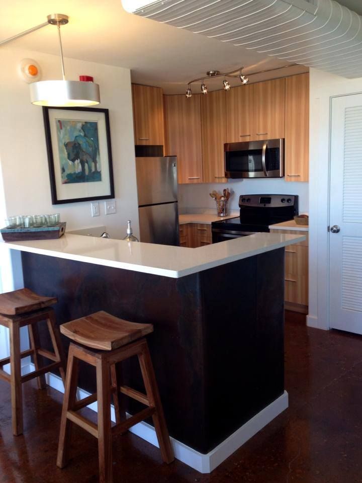 a kitchen with stools and a picture on the wall