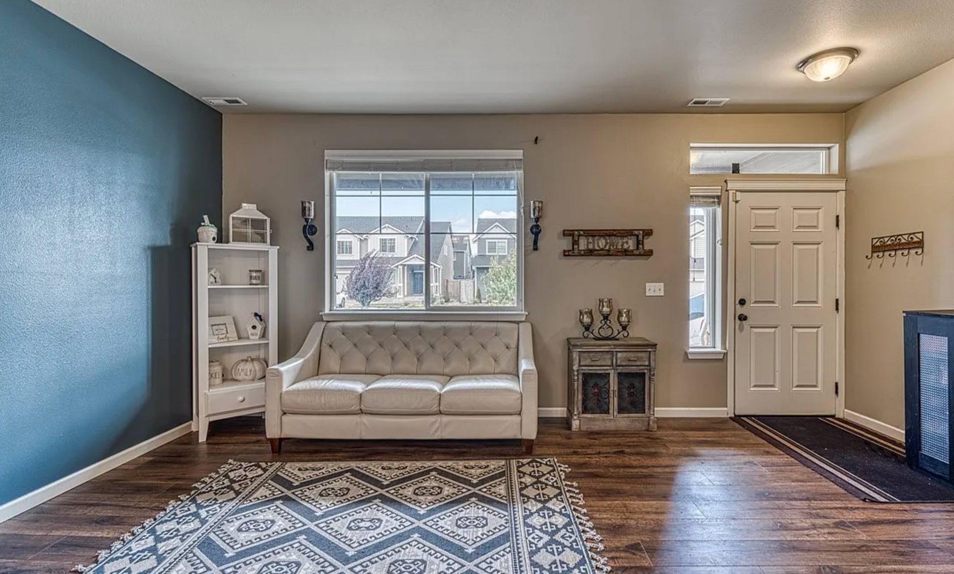 A living room with a couch , rug , and window.