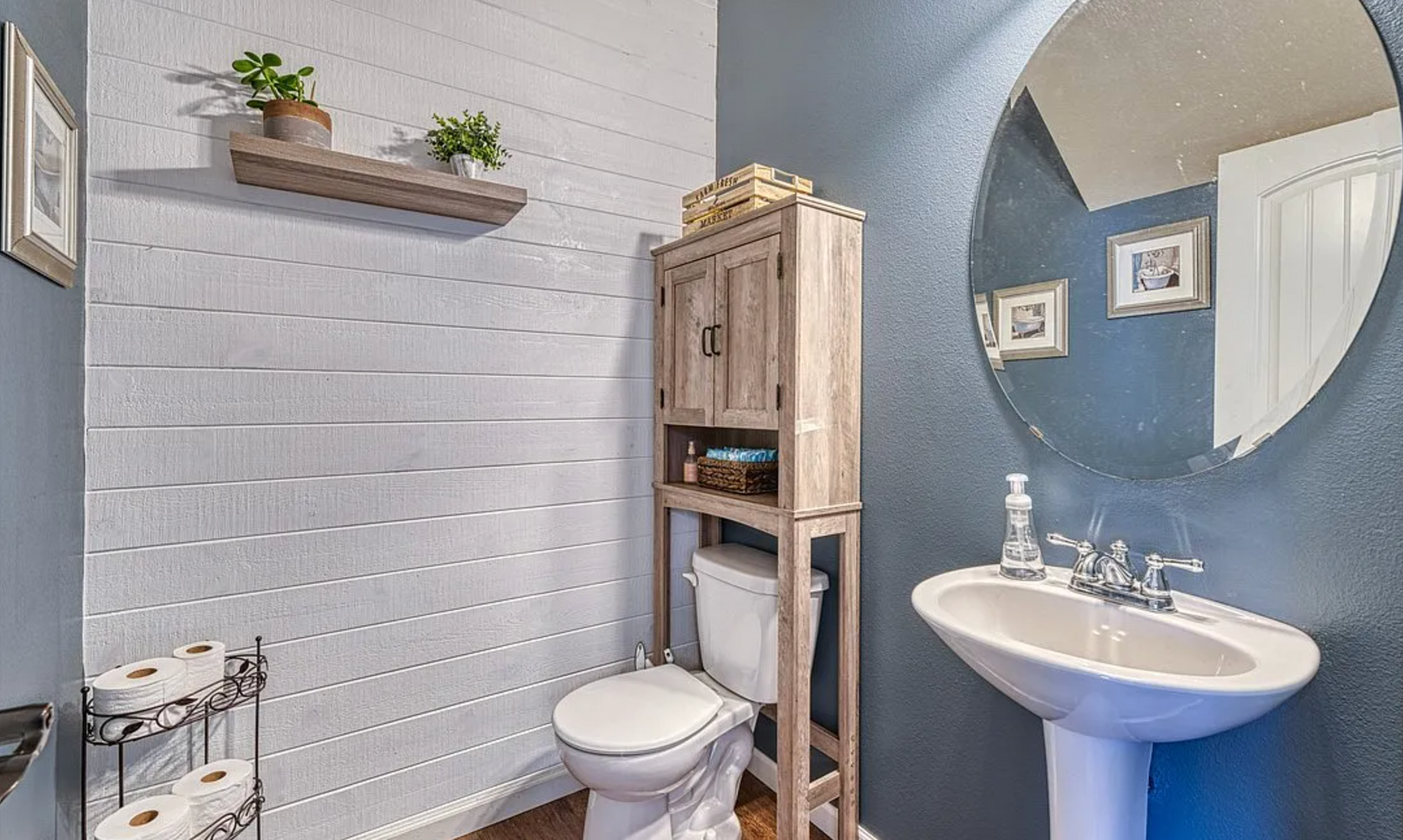 A bathroom with a toilet , sink and mirror.