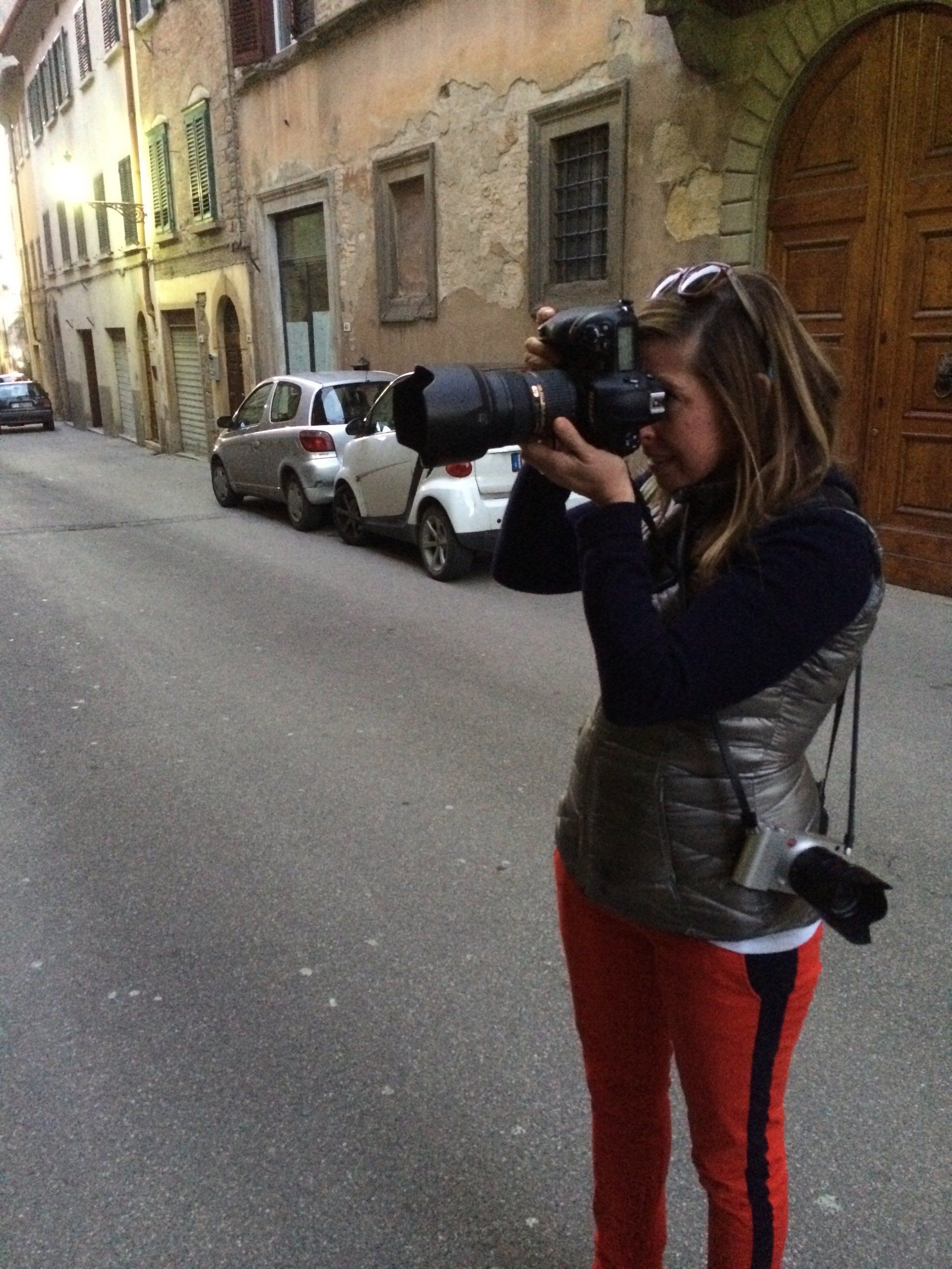 a woman is taking a picture of a street with a camera .