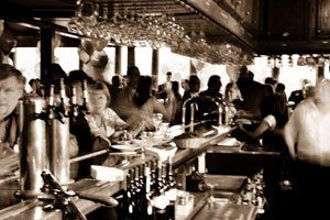 A crowd of people are gathered at a bar.
