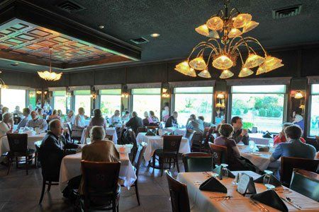 A group of people are sitting at tables in a restaurant.