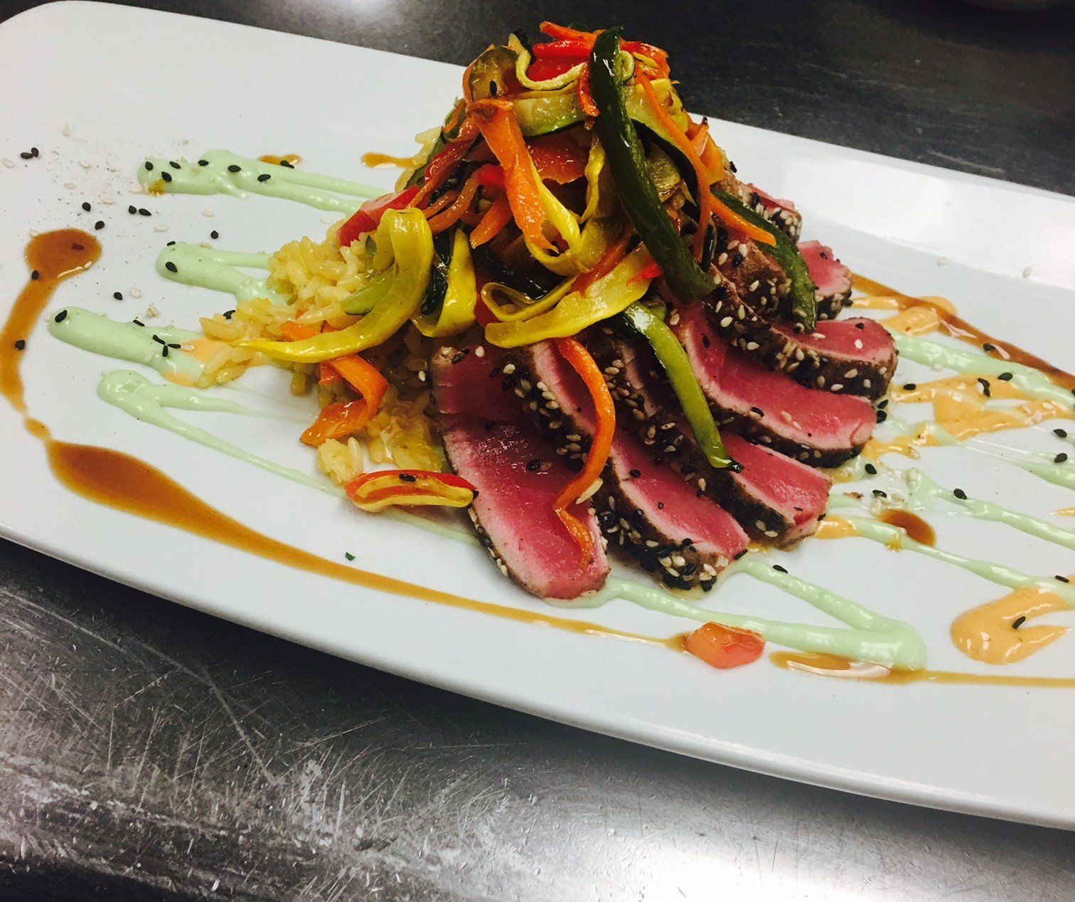 A white plate topped with sliced meat and vegetables